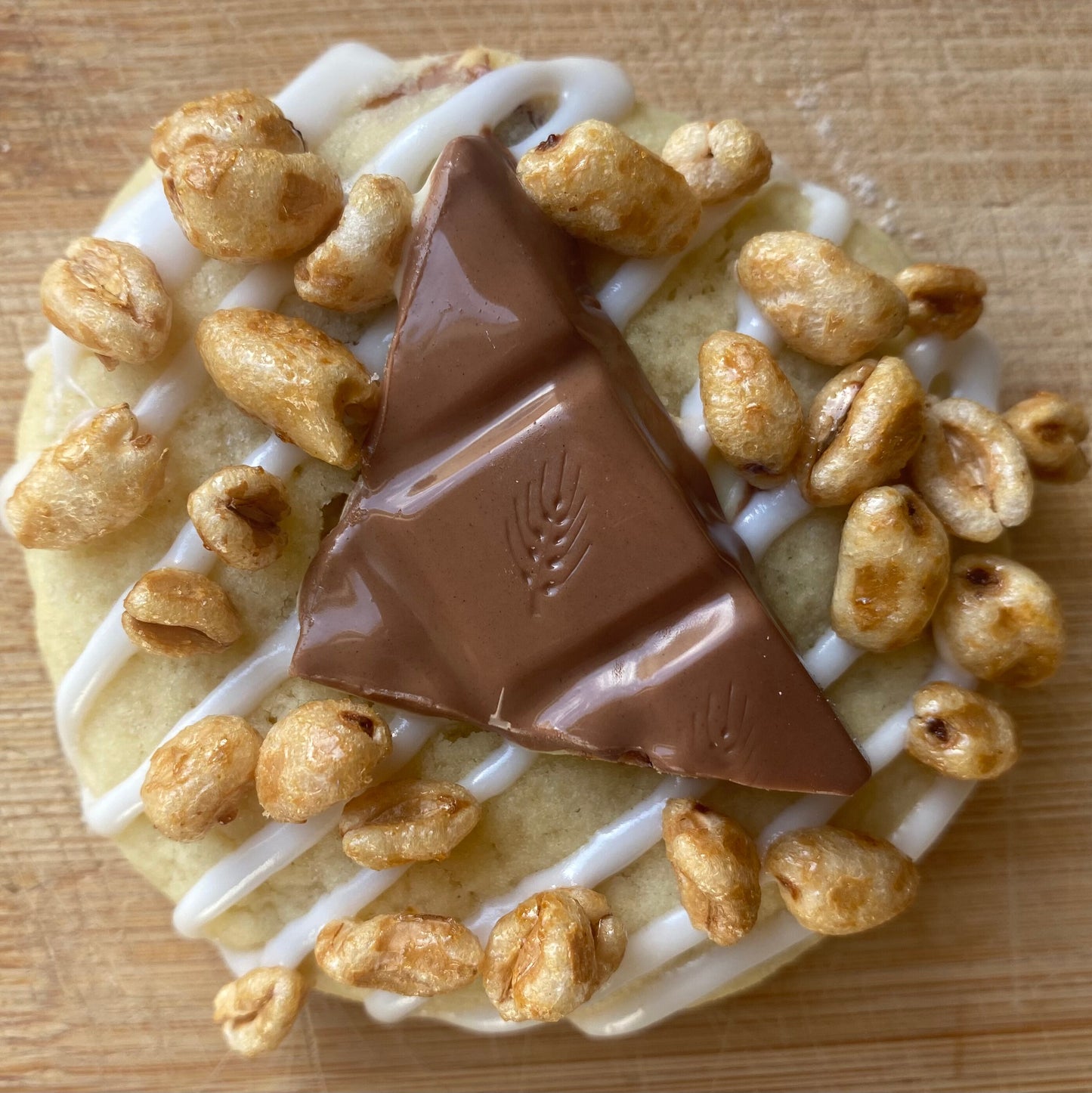 Cookie avec du riz soufflé dessus et un beau morceau de Kinder Country. Glaçage blanc, unn délicieux cookie fait maison qui vous garanti la fraîcheur de chaque ingrédient.