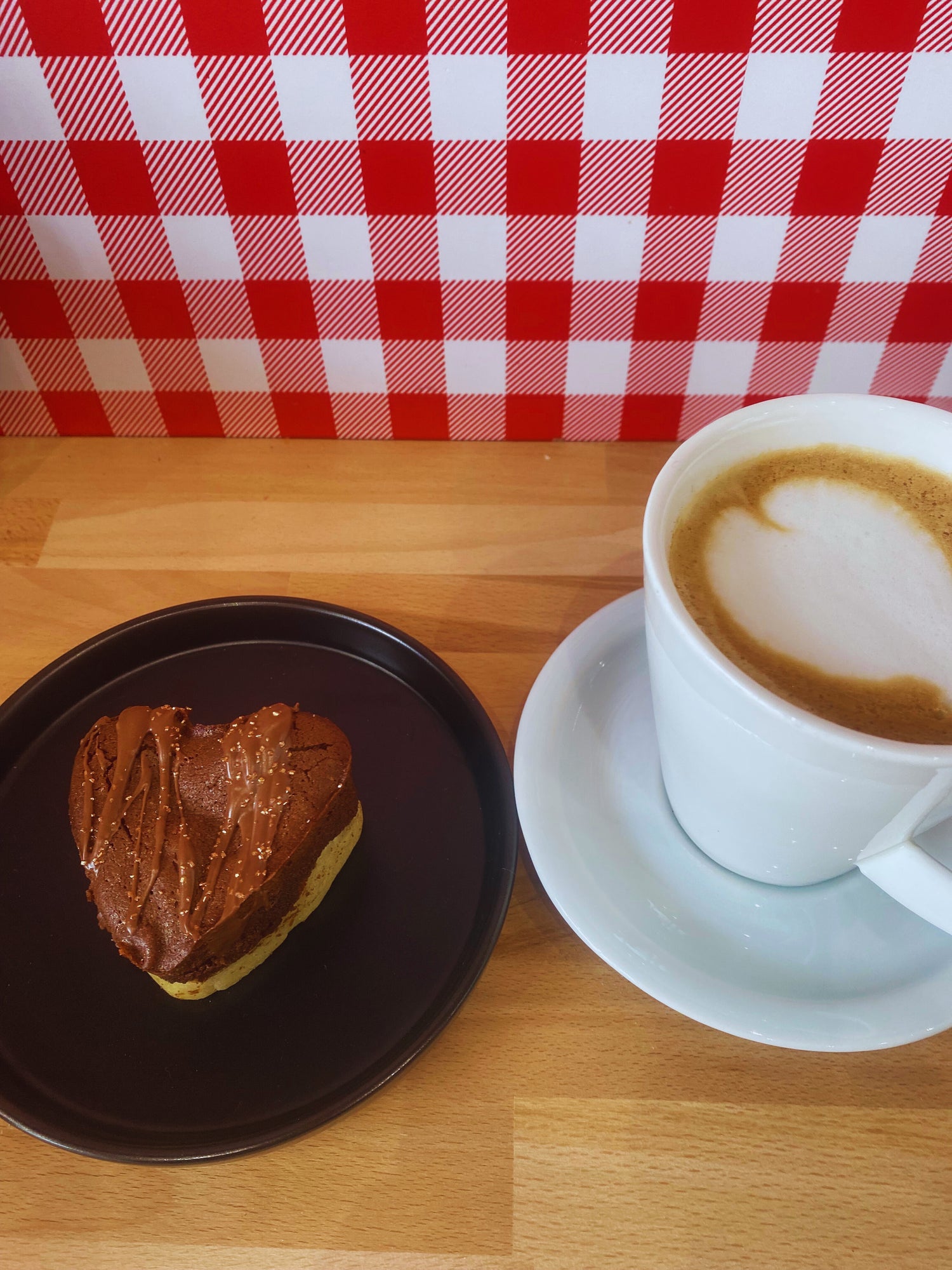 Visuel avec un café façon bariste avec un coeur de lait, accompagné d'un brookie coeur Nutella.